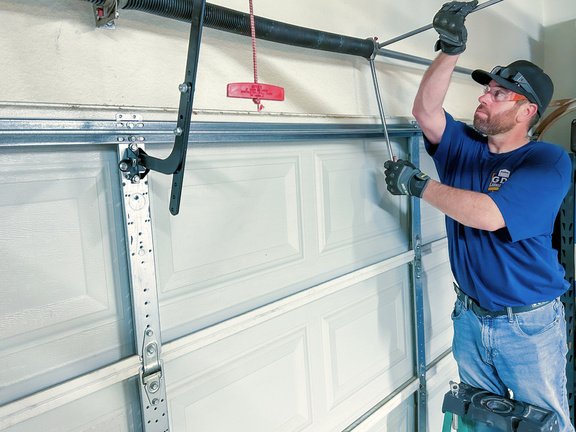Technician repairing garage door spring in Mississauga
